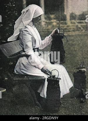 Lady Stradbroke, ehemals Helena Fraser und Ehefrau von George Rous, 3. Earl of Stradbroke, in Krankenschwester-Uniform im Familienhaus von Henham Hall in Suffolk abgebildet, in dem über die Bomben nachgedacht wird, die von deutschen Flugzeugen im April 1915 abgeworfen wurden. Das Haus wurde während des Ersten Weltkriegs in ein Militärkrankenhaus umgewandelt und erhielt Konvois von verwundeten Soldaten direkt aus Frankreich, die einst ausreichend gut an das Rote Kreuz weitergegeben wurden. Lady Stradbroke übernahm die alleinige Verantwortung als Oberschwester und überplante das Krankenhaus effizient. Henham Hall wurde 1953 abgerissen. Stockfoto