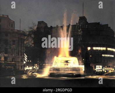 Der Brunnen am Trafalgar Square, London, wurde in der Dämmerung angezündet. Stockfoto