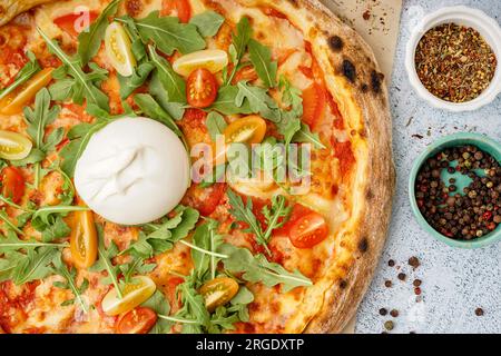 Leckere Pizza mit Burrata-Käse auf grauem Hintergrund Stockfoto