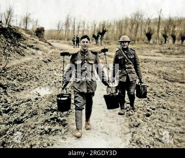 Ein britischer Soldat, der im Ersten Weltkrieg zwei Eimer Wasser an der Westfront mit einem Joch transportierte. Der Mann hinter ihm trägt zwei Dosen. Stockfoto