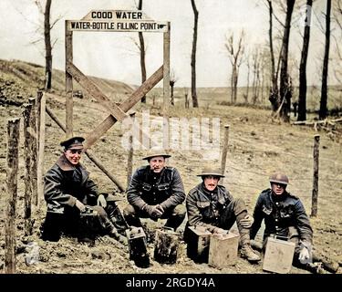 Vier britische Soldaten mit Wasserkannen in der Nähe eines Versorgungspunkts an der Westfront im Ersten Weltkrieg. Stockfoto