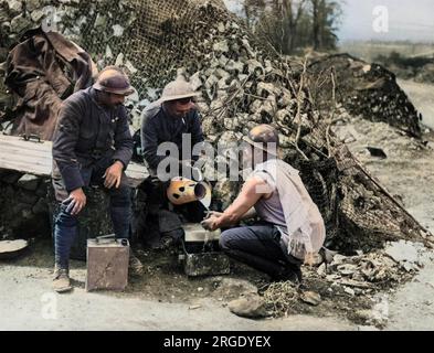 Ein britischer Soldat, der einem französischen Soldaten beim Morgenwaschen an der Westfront in Frankreich während des Ersten Weltkriegs half. Stockfoto