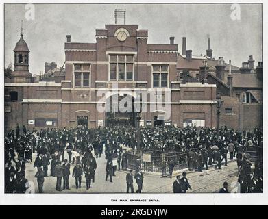 Blick auf die Haupteingangstore des Woolwich Arsenal im Südosten Londons, mit einer großen Menschenmenge. Stockfoto