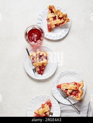 Scheiben Vegan Strawberry Rhubarb Pie auf weißen Tellern Stockfoto