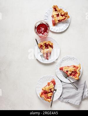 Scheiben Vegan Strawberry Rhubarb Pie auf weißen Tellern Stockfoto