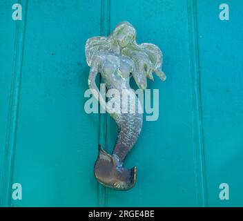 Türklopfer aus Messing mit einer Meerjungfrau auf einer türkisfarbenen Tür Stockfoto