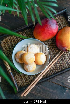 japanische Mango-Mochi-Kuchen mit Eiscreme auf einem klassischen asiatischen Holztablett Stockfoto