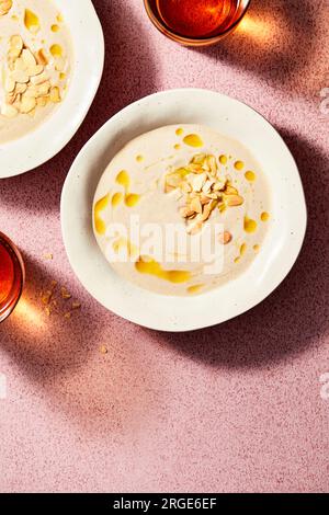 Gekühlte Mandelsuppe auf rosa Hintergrund Stockfoto