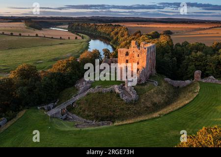 Sonnenuntergang am Norham Castle hoch über dem Fluss Tweed an der Grenze zu Schottland, eines der wichtigsten der anglo-schottischen Grenzschlösser Stockfoto