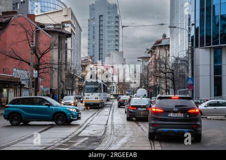 Bild einer Straßenbahn von Bukarest, die mitten in einem Stau im Stadtzentrum vorbeifährt. Straßenbahnen sind eine Form des öffentlichen Nahverkehrs in der Stadt Stockfoto