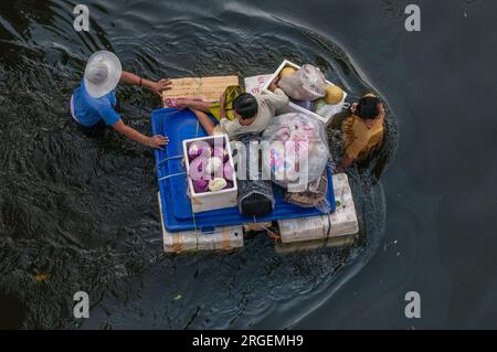 Über dem Kopf von thailändischen Flüchtlingen auf einem provisorischen Floß, das durch gefährliche Überschwemmungen in Rangsit, einem nördlichen Vorort von Bangkok, Thailand, fährt. © Kraig Lieb Stockfoto