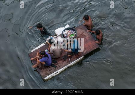 Über dem Kopf von thailändischen Flüchtlingen auf einem provisorischen Floß, das durch gefährliche Überschwemmungen in Rangsit, einem nördlichen Vorort von Bangkok, Thailand, fährt. © Kraig Lieb Stockfoto