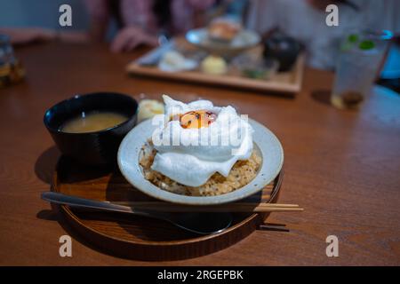 Fusionsküche. Eierschaum auf gebratenem Reis. Japanischer Stil. Holztisch. Stockfoto