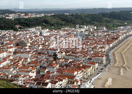 Stadt Nazare, Portugal - Blick unter die Klippen. Blick von oben auf die Stadt Nazare und den Sandstrand. Die größten Wellen der Welt sind in Nazare, Leiria Distric Stockfoto