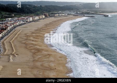 Stadt Nazare, Portugal - Blick unter die Klippen. Blick von oben auf die Stadt Nazare und den Sandstrand. Die größten Wellen der Welt sind in Nazare, Leiria Distric Stockfoto