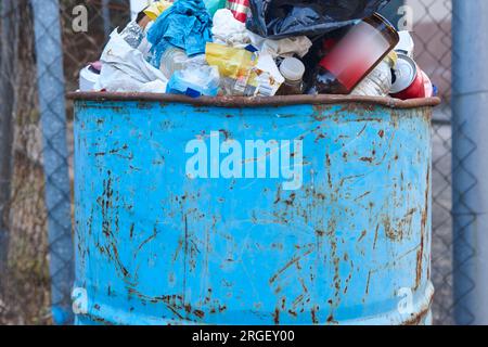 Rostige Mülltonne voller Müll. Papierkorb-Management. Umweltproblem Stockfoto