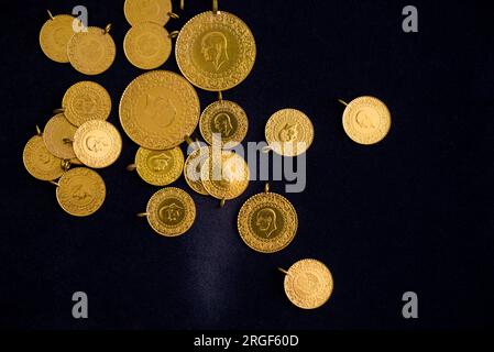 Der Haufen voller, halber und Viertel türkischer Goldmünzen auf dunkelmarineblauem Hintergrund Stockfoto