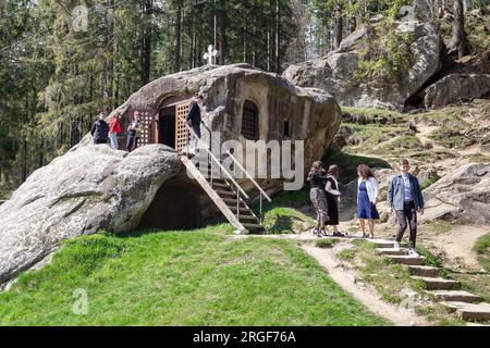PUTNA, RUMÄNIEN - 30. APRIL 2023: Zahlreiche Pilger und Touristen besuchen den Felsen mit der Höhle von Daniel dem Eremit. Stockfoto