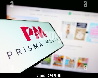 Handy mit Logo des französischen Verlagsunternehmens Prisma Media auf dem Bildschirm vor der Business-Website. Fokus auf die Mitte links des Telefondisplays. Stockfoto