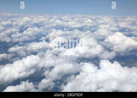 Blick über die Wolken mit Land sichtbar unter dem Flugzeugfenster auf dem Ägäischen Flug nach Griechenland Stockfoto