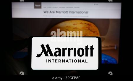 Person, die ein Smartphone mit dem Logo des US-amerikanischen Hotelunternehmens Marriott International Inc. Auf dem Bildschirm vor der Website hält. Konzentrieren Sie sich auf das Display des Telefons. Stockfoto