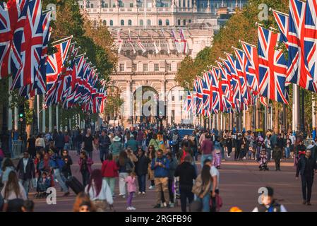 Besucher, die während des Urlaubs vor dem Buckingham Palace spazieren gehen Stockfoto