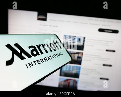 Mobiltelefon mit Logo des US-amerikanischen Hotelunternehmens Marriott International Inc. Auf dem Bildschirm vor der Website. Fokus auf die Mitte links des Telefondisplays. Stockfoto