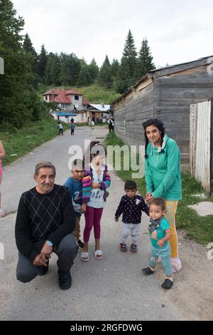 Romany Zigeunerfamilie, Großvater, Tochter und Enkel. Familien haben oft mindestens sechs Kinder, ein Mehrgenerationenhaus im Hintergrund. Zigeuner-Siedlung am Stadtrand von Sumiac, Bezirk Brezno, Slowakei, August 2023. 2020s HOMER SYKES Stockfoto