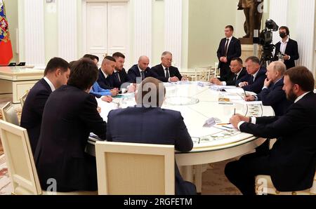 Moskau, Russland. 08. Aug. 2023. Der russische Präsident Wladimir Putin, rechts im Zentrum, hört sich einen Bericht während eines Treffens mit den Leitern der Bauindustrie im Kreml an, der am 8. August 2023 in Moskau, Russland, stattfand. Kredit: Mikhail Klimentyev/Kremlin Pool/Alamy Live News Stockfoto