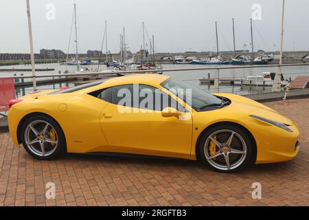 Seitenansicht des gelben Ferrari 458 Italia Sportwagen am Hafen in der niederländischen Stadt Lelystad, Niederlande - Juni 18 2023 Stockfoto
