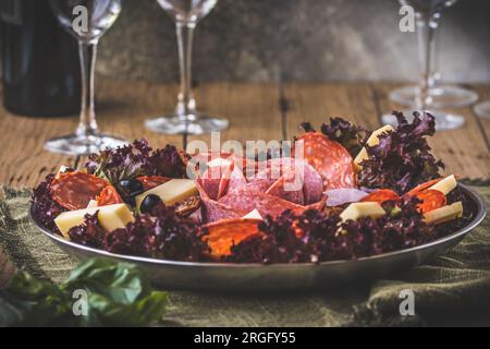 Traditionelles italienisches Antipasti auf einem Teller serviert mit Oliven. Aperitif, Mittagessen oder Buffet in einem Restaurant. Stockfoto