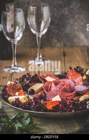 Traditionelles italienisches Antipasti auf einem Teller serviert mit Oliven. Aperitif, Mittagessen oder Buffet in einem Restaurant, vertikal. Stockfoto