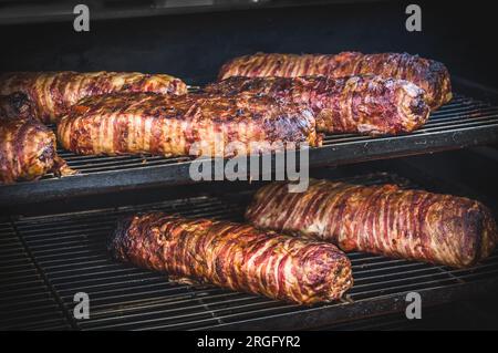 Großer Barbecue-Rauchergrill auf einem öffentlichen Festival. Fleisch und Speck, zubereitet im Barbecue-Raucher. Stockfoto