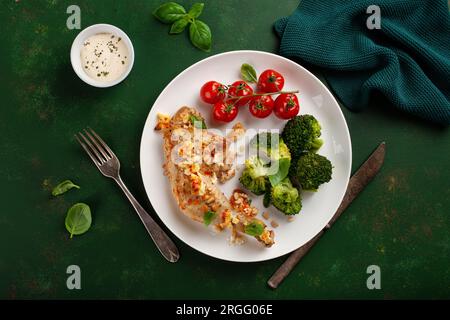 Hühnerschenkel mit Feta-Käse-Tomaten und Brokkoli, gesunde Keto-Mahlzeit Stockfoto