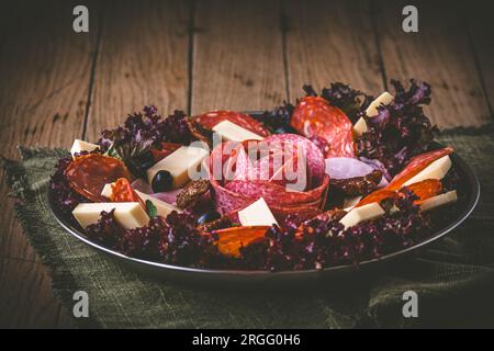 Traditionelles italienisches Antipasti auf einem Teller serviert mit Oliven. Aperitif, Mittagessen oder Buffet in einem Restaurant. Stockfoto