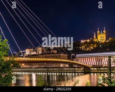 Blick auf die beleuchtete Fußgängerbrücke Saint Georges, Vieux Lyon und Saone bei Nacht in Lyon, Frankreich. Stockfoto