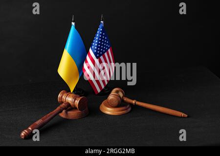 Zwei Hammer mit USA-Flagge und ukrainischer Flagge auf schwarzem Hintergrund Stockfoto