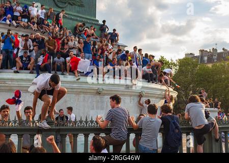 Paris, Frankreich, 2018. Junge Männer klettern den Zaun hoch und runter, um an der Juli-Säule, dem Place de la Bastille, den Tag zu feiern, an dem Frankreich die Weltmeisterschaft gewann Stockfoto