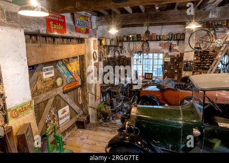 Ausstellung von Motorobjekten in einer Garage der 1930er Jahre im National Motor Museum, Beaulieu, New Forest, Hampshire, England, UK. Stockfoto