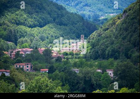 Umgeben von steilen bewaldeten Berghängen und auf dem Talboden des Valle Ombrosa (Schattental) mit Olivenhainen und Landwirtschaft liegt das Dorf Posa Stockfoto