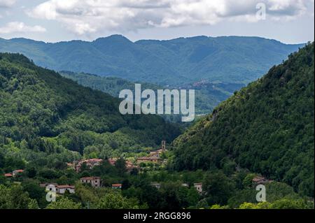 Umgeben von steilen bewaldeten Berghängen und auf dem Talboden des Valle Ombrosa (Schattental) mit Olivenhainen und Landwirtschaft liegt das Dorf Posa Stockfoto