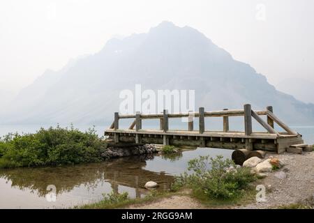 Der Rauch zahlreicher wilder Feuer in den Rockies verhüllt die Berge mit Rauch und Dunst. Brücke mit Blick auf Bow Lake, Icefields Parkway, Alberta, Kanada Stockfoto