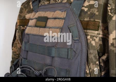 Soldat in grauer kugelsicherer Jacke mit Banner der ukrainischen Flagge. Stockfoto