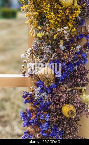 Schöne Dekoration von getrockneten Blumen auf einem Holzbalken, vertikal Stockfoto