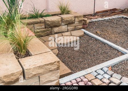 Schaffung einer gepflasterten Fläche in einem Garten oder Park, Pflasterarbeiten. Pflastersteine werden in einem Muster verlegt. Stockfoto