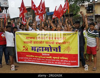 Mumbai, Indien. 09. Aug. 2023. Demonstranten halten während eines Protests gegen die Neuentwicklung von Dharavi (Asiens größter Slumkolonie) durch die Adani Group in Mumbai ein Banner und Flaggen. Die Bewohner von Dharavi, die seit Jahren lokale Unternehmen betreiben, haben das Gefühl, dass die Sanierung sie vertreiben wird, und die Adani-Gruppe wird den Ort für ihren eigenen Profit ausnutzen und ihn zu einem Spielplatz für die Reichen machen. Kredit: SOPA Images Limited/Alamy Live News Stockfoto