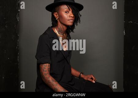 Junge Frau mit Tattoos mit schwarzen Hut Stockfoto