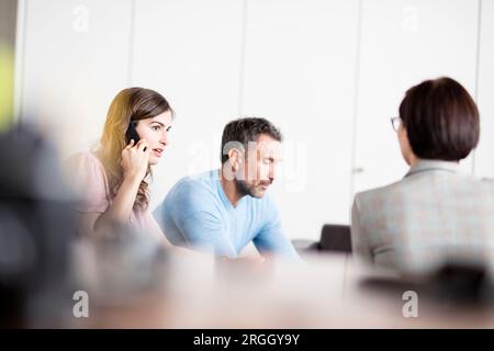Junge Geschäftsfrau, Reden auf dem Smartphone während der Konferenz Stockfoto