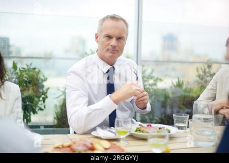 Ernsthafte Geschäftsmann holding Gläser während der Sitzung im Restaurant Stockfoto