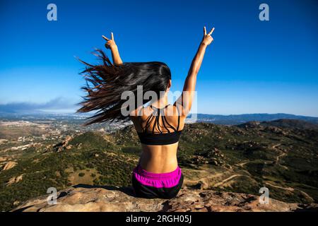 Junge Frau Frieden Geste auf dem Berg Stockfoto